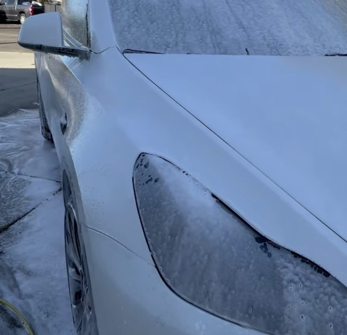 White Tesla covered in foam during the wash